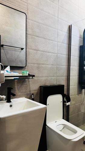 a bathroom with a white toilet and a sink at جوهرة الرستاق السياحية in Far‘