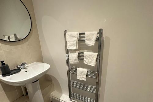a white bathroom with a sink and a mirror at 2Bed Apartment-Free Parking Pets Garden Central in London