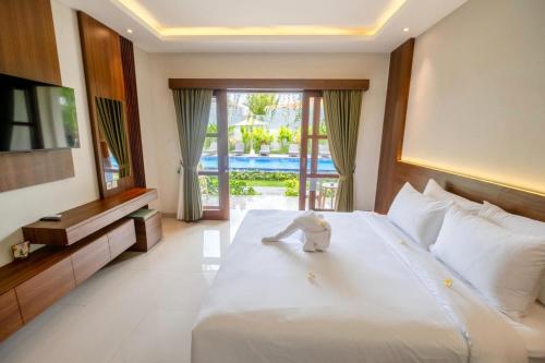 a bedroom with a bed with a stuffed animal on it at Puri Kaja House in Badung