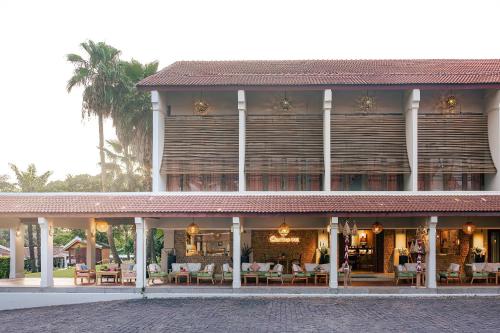 a building with tables and chairs in front of it at Palm Garden Beach Resort & Spa in Hoi An