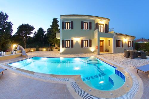 a villa with a swimming pool in front of a house at Villa Emily in Fiskardho