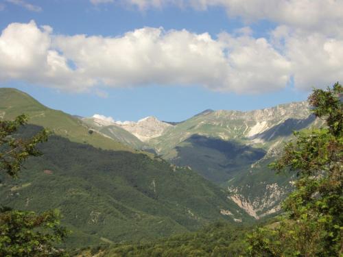 a view of a mountain valley with snow capped mountains at La Colombella in Montemonaco