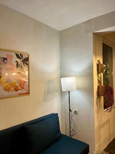 a living room with a blue couch and a lamp at Almadovarhouse in Makhinjauri