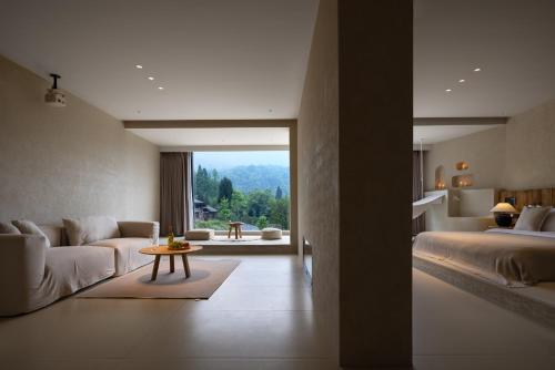 a bedroom with a bed and a couch and a table at Twilight Cloud Spring Tree Private Hot Spring Homestay Bifengxia Panda Base Store in Ya'an