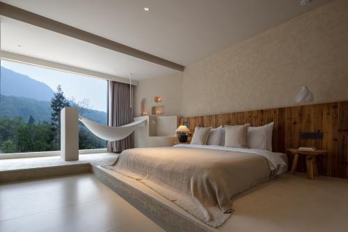 a bedroom with a large bed and a large window at Twilight Cloud Spring Tree Private Hot Spring Homestay Bifengxia Panda Base Store in Ya'an