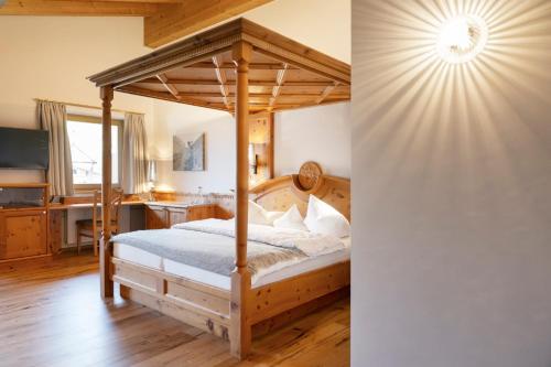a bedroom with a canopy bed and a desk at Hotel Stubaierhof in Neustift im Stubaital