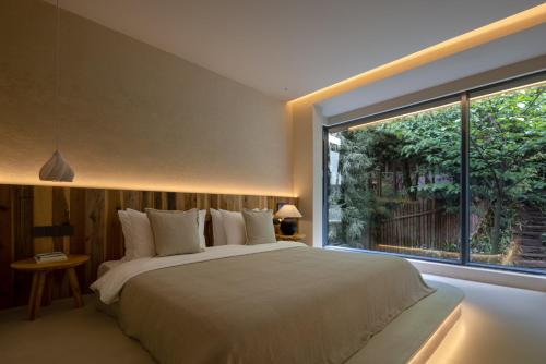 a bedroom with a large bed and a large window at Twilight Cloud Spring Tree Private Hot Spring Homestay Bifengxia Panda Base Store in Ya'an