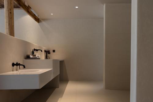 a white bathroom with a sink and a shower at Twilight Cloud Spring Tree Private Hot Spring Homestay Bifengxia Panda Base Store in Ya'an