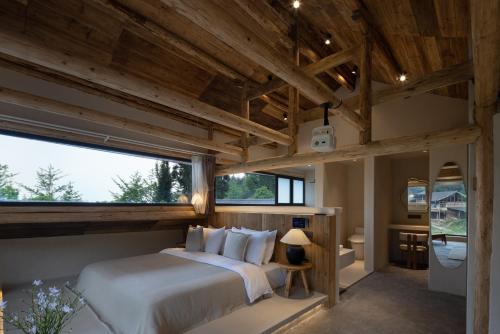 a bedroom with a large bed and large windows at Twilight Cloud Spring Tree Private Hot Spring Homestay Bifengxia Panda Base Store in Ya'an
