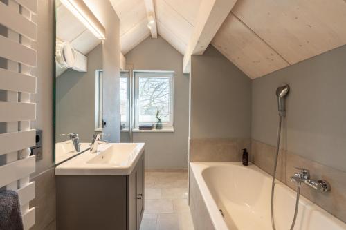 a bathroom with a tub and a sink and a bath tub at Ferienwohnung 2 K20 in Borkum