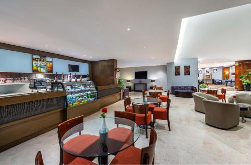 a restaurant with tables and chairs and a bar at Razana Hotel Al Jubail in Al Jubayl