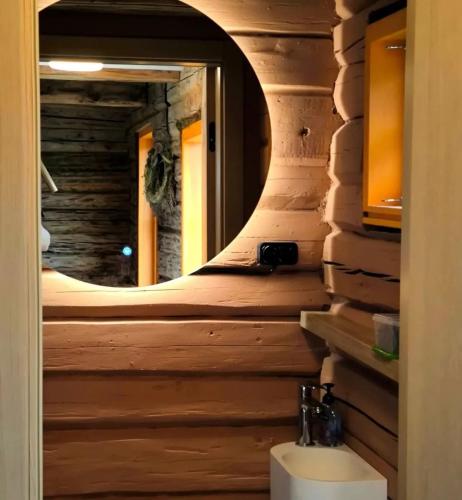 a bathroom in a log cabin with a mirror at Sunset sauna Bauska in Jumprava