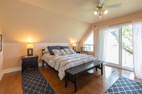 a bedroom with a bed and a large window at Riverside - Spa - Le Laurentien in Saint-Antoine-Lotbinière