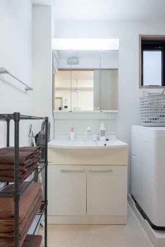 a white kitchen with a sink and a refrigerator at Private House NISHIOGI in Kichijōji
