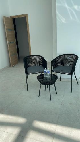 two black chairs and a table with water bottles on it at EXCEPTIONNEL Studio VERSAILLES in Le Chesnay