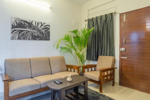 a living room with a couch and two chairs at Housr Ferguson Marathahalli, Bengaluru in Bengaluru