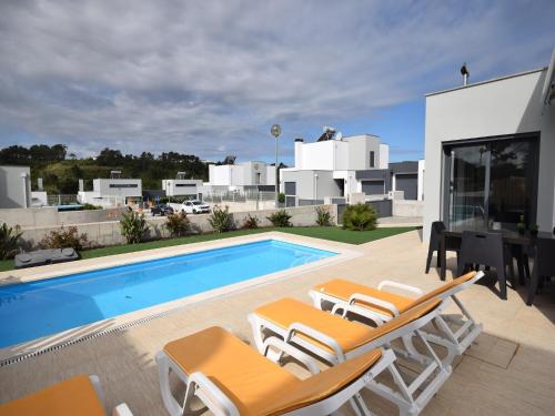 a villa with a swimming pool and lounge chairs at Family Villa with Terrace and Pool in Foz do Arelho