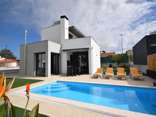 a villa with a swimming pool in front of a house at Family Villa with Terrace and Pool in Foz do Arelho
