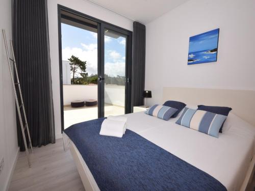 a bedroom with a large bed and a large window at Family Villa with Terrace and Pool in Foz do Arelho
