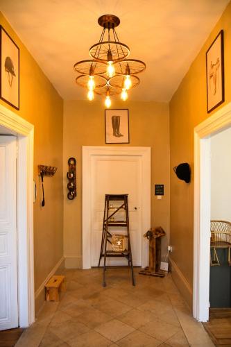 a room with a ladder and a chandelier at Les crins du vignoble in Loches-sur-Ource