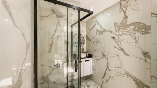 a shower with a glass door in a bathroom at Palmera Resort Wellness & SPA in Kérynia