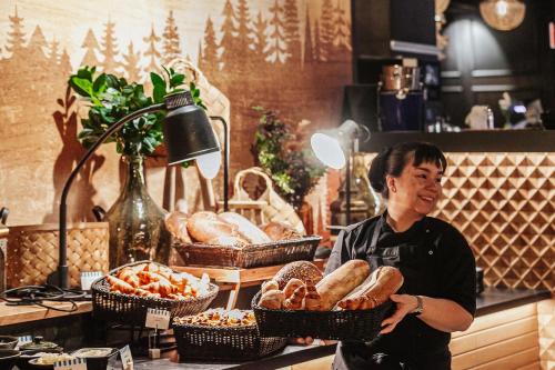 Eine Frau steht hinter einem Tresen mit Brotkörben. in der Unterkunft Break Sokos Hotel Tahko in Tahkovuori