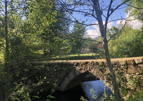 an old stone bridge over a river in a park at Peneda-Gerês - Nature Pool - Garden - Parking free in Sabadim