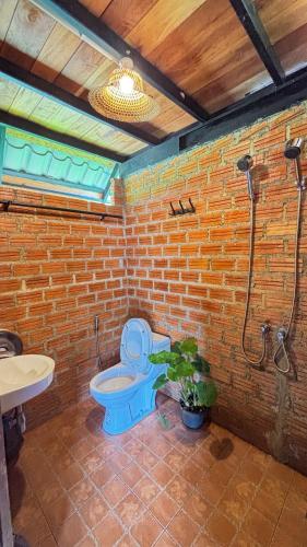 a bathroom with a blue toilet and a shower at DeeTorJai FarmStay Nan ดีต่อใจ ฟาร์มสเตย์ น่าน โดยเจ้าของ in Ban Klang