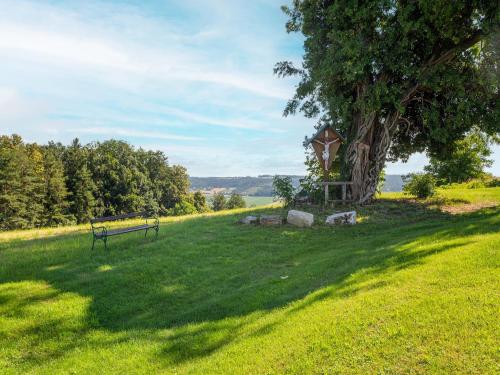 a park bench next to a tree in a field at Holiday Home in Styria near Thermal Spas in Gersdorf an der Feistritz
