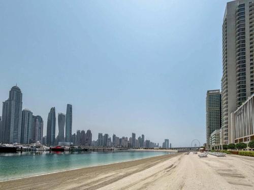 a beach in the middle of a city with tall buildings at Luxury 3BR Palm Views at Emaar Beachfront in Dubai
