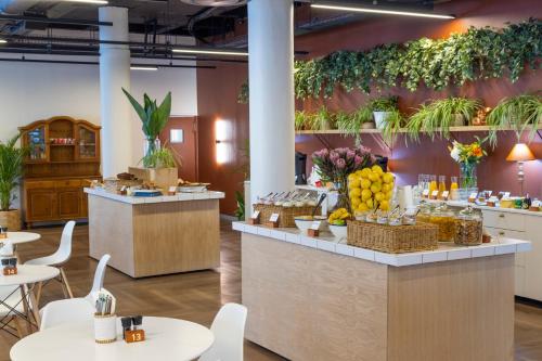 a restaurant with tables and a counter with fruits and vegetables at WINK Aparthotel One Thibault in Cape Town