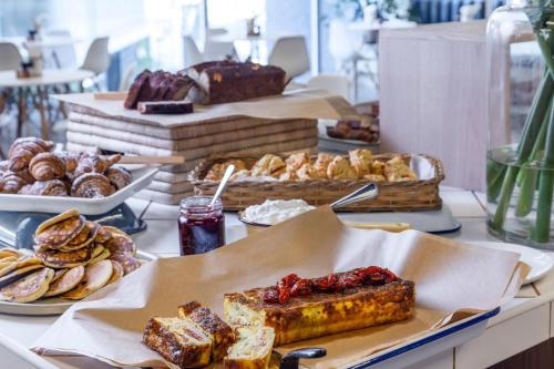 a buffet of pastries and breads on a table at WINK Aparthotel One Thibault in Cape Town