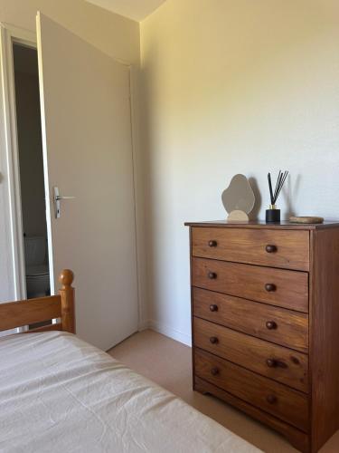 a bedroom with a wooden dresser and a bed at Appartement Vieville in Viéville