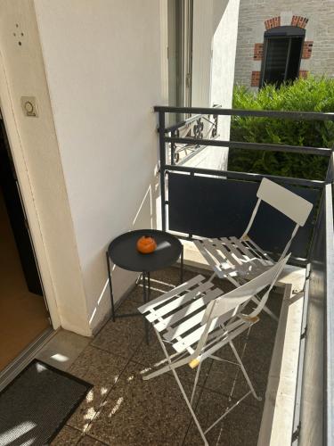 a pair of chairs and a table on a balcony at Appartement Vieville in Viéville