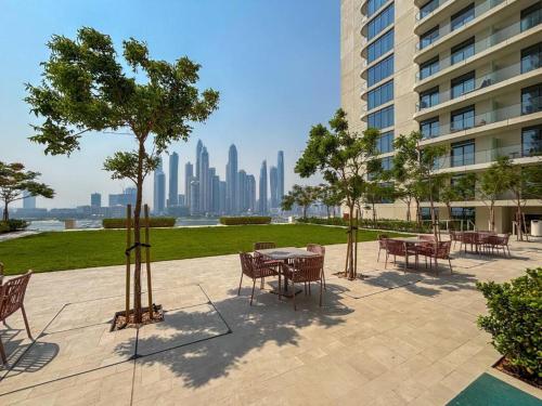 a patio with tables and chairs with a view of the city at Luxury 3BR Palm Views at Emaar Beachfront in Dubai