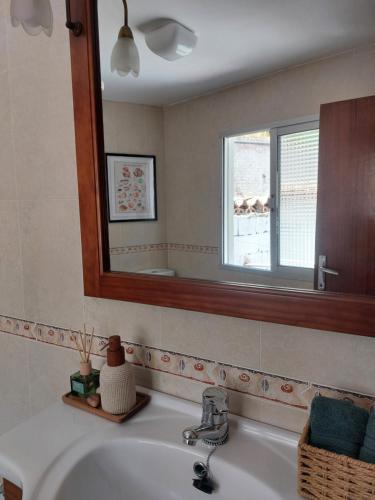 a bathroom sink with a mirror and a window at Casa de la abuelita in Cazorla