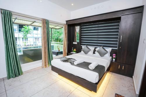 a bedroom with a large bed and a large window at Moonveil Premium Villa Munnar in Anachal