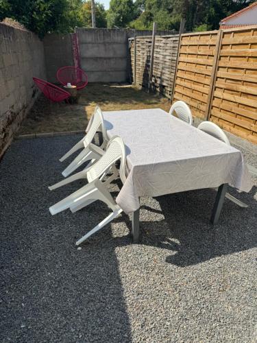 a table with two chairs and a mattress on it at Logement proche Aéroport Nantes in Saint-Aignan-Grand-Lieu