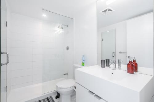 a white bathroom with a sink and a toilet at Corner 2 Bedroom 2 Bathroom Condo Balcony Iceboat Terrace Downtown Toronto in Toronto