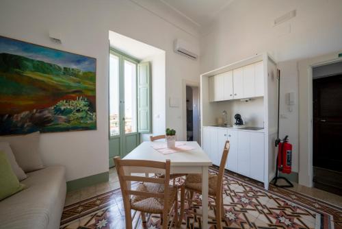 a living room with a table and chairs and a kitchen at Casa Zizzi - appartamento romantico per 2 in Puglia in Montalbano