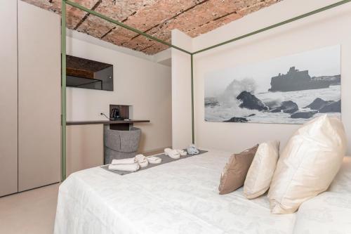 a bedroom with a white bed and a painting on the wall at Spazio Pardo in Catania