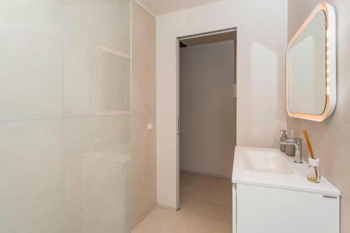 a white bathroom with a sink and a mirror at Spazio Pardo in Catania