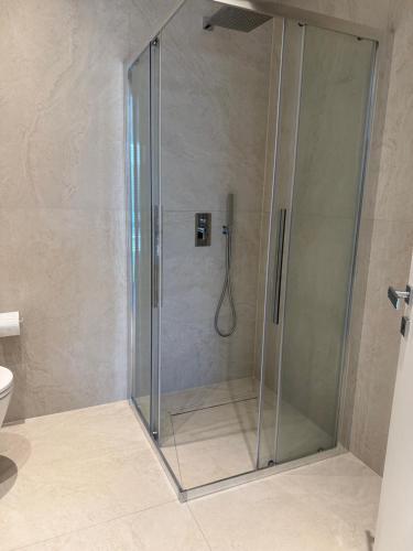 a shower with a glass door in a bathroom at Darion Luxury Villa Nikiti Chalkidiki in Nikiti