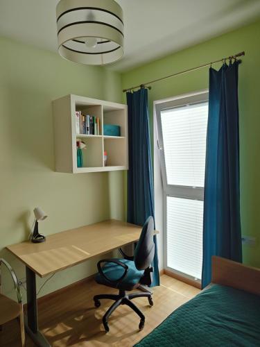 a bedroom with a desk and a chair and a window at OCTAVIAN SUITE in Warsaw