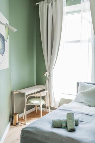 a bedroom with a bed and a desk and a window at HOME1 - Augarten City Stay Boutique Hostel in Vienna
