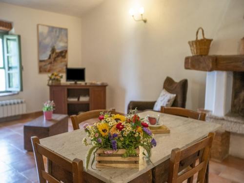 a dining room table with a centerpiece of flowers on it at Appealing Apartment in Collesalvetti with Garden in Nugola