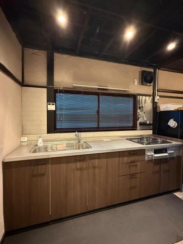 a kitchen with a sink and a stove at 一棟貸し宿 ｍａｉｃｃａ in Numazu