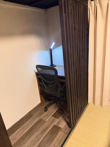 an office with a desk with a chair and a lamp at 一棟貸し宿 ｍａｉｃｃａ in Numazu