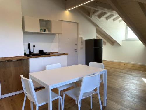 a kitchen with a white table and white chairs at Attico vista Lago in Centro in Luino