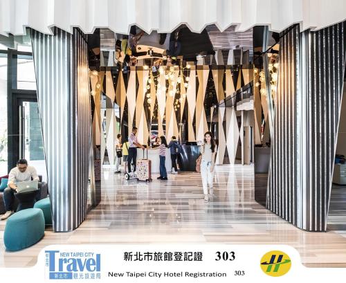 a lobby of a building with people walking around at HOTEL CHAM CHAM - Taipei in Taipei